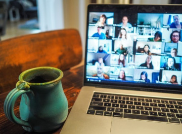 Zoom meeting on a laptop next to a mug