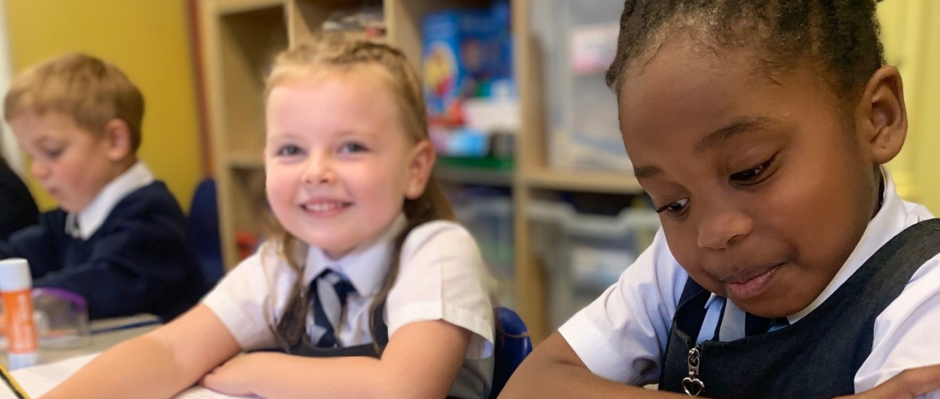3 primary school children at a desk