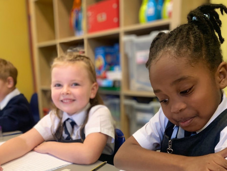 3 primary school children at a desk